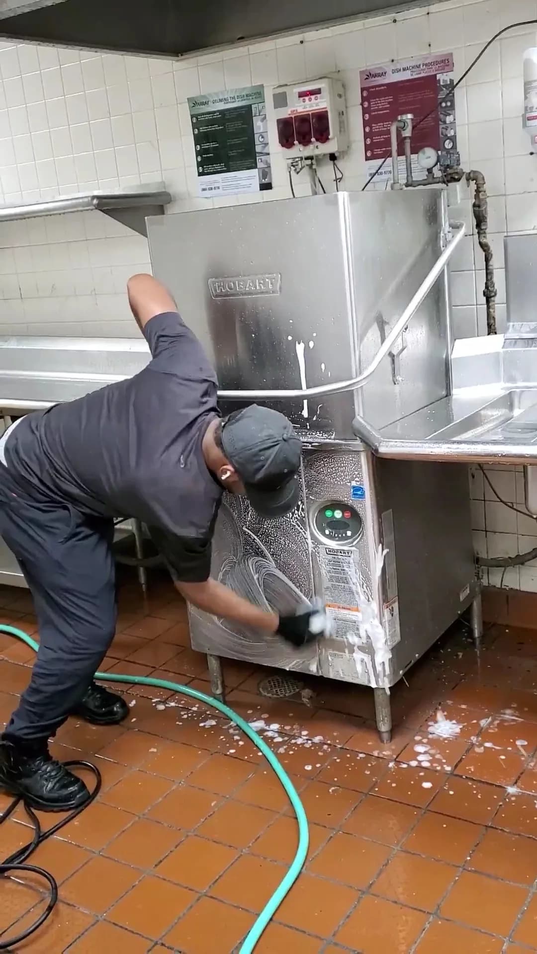 Technician cleaning the exterior of a commercial dishwasher — company portfolio, Michigan